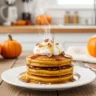 Delicious stack of pumpkin pancakes recipe with whipped cream and pecans