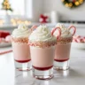 Close-up of festive peppermint christmas shots garnished with whipped cream and candy canes